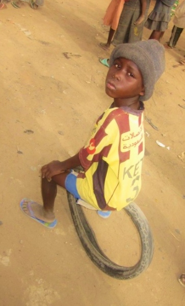 Chłopiec z N'djameny. Popularna zabawa "toczenie opony" 