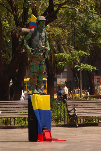 Partyzant FARC zarabia na życie na placu Botero w Medellin.