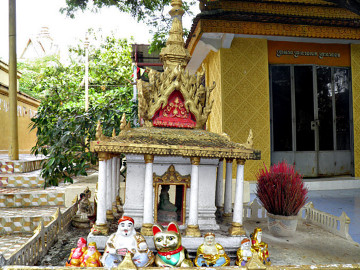 BUDDYZM. Khmerski dom ofiarny 'pteah neak taa' połączony z japońskim kultem kota 'maneki-neko'. 