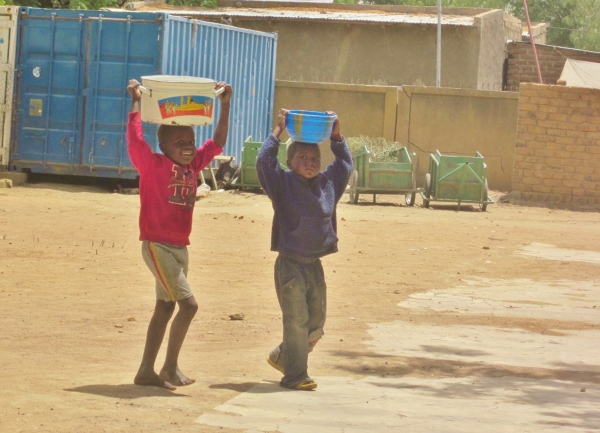 Dzieci niosące wodę ze studni.